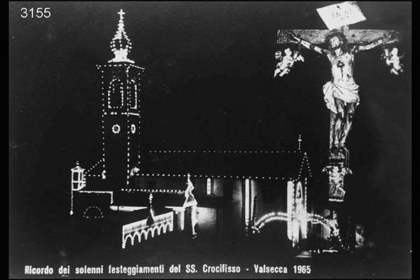 Notturno, Valsecca. - Cartolina con: in alto a destra foto di un crocifisso ripresa notturna di una chiesa in basso, la scritta: "Ricordo dei solenni festeggiamenti del SS: Crocifisso - Valsecca 1965.