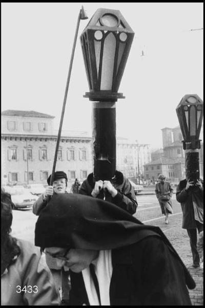 Carnevale ambrosiano. Piazza Fontana, persone mascherate da lampioni.