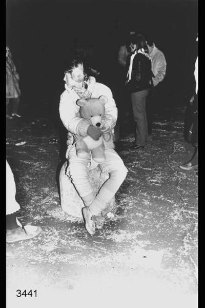 Carnevale ambrosiano. Ragazza seduta con in mano un orsacchiotto.