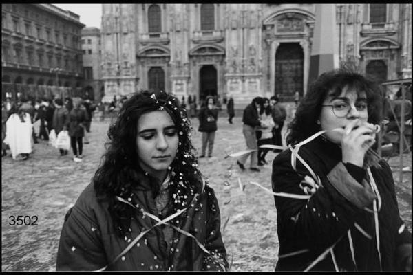 Carnevale ambrosiano. Due ragazze coperte di stelle filanti e coriandoli in Piazza Duomo la mattina del sabato grasso.