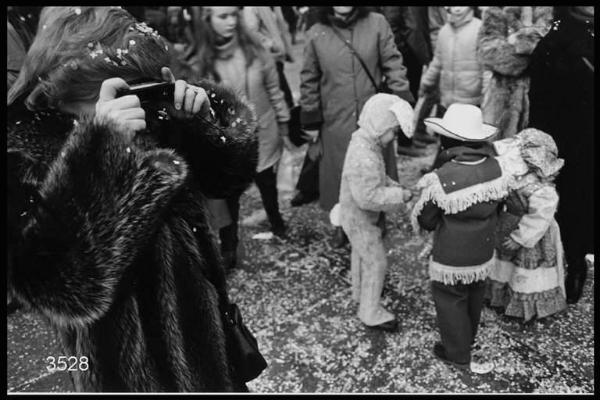 Carnevale ambrosiano. Signora con pelliccia ripresa mentre sta fotografando.