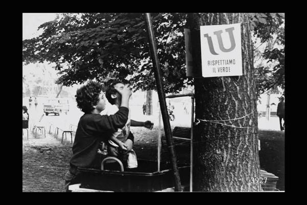 Milano. Parco Sempione. Festa dell'Unità: due bambini di fronte a una fontanella.