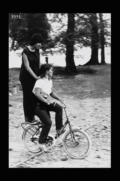 Milano. Parco Sempione. Festa dell'Unità: due ragazze in bicicletta.