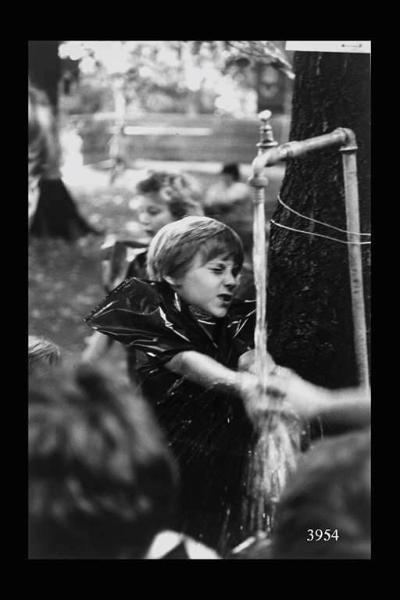 Milano. Parco Sempione. Festa dell'Unità: bambino si lava a una fontanella.