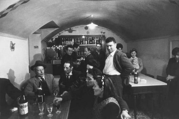 Canto popolare, gruppo di Santa Croce. Canto in osteria: cantori intorno a un tavolo e persone in piedi.