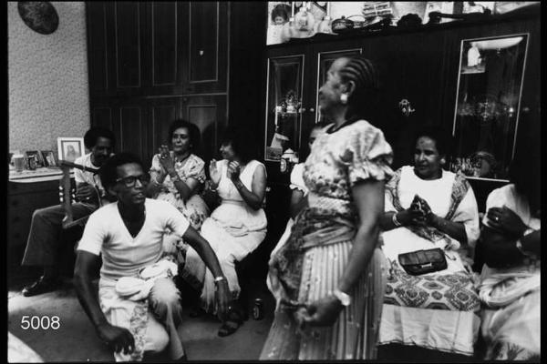 Festa di compleanno. Eritrei. Interni di abitazione. Coppia danza accompagnata dal battito di mani delle donne.