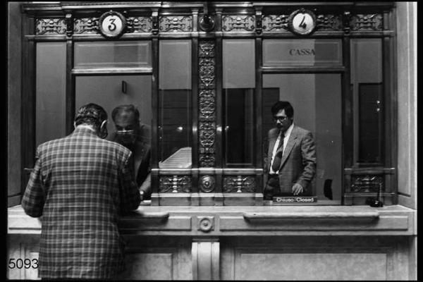 Milano. Sede centrale della Banca Commerciale Italiana in Piazza della Scala. Impiegati e cliente agli sportelli.