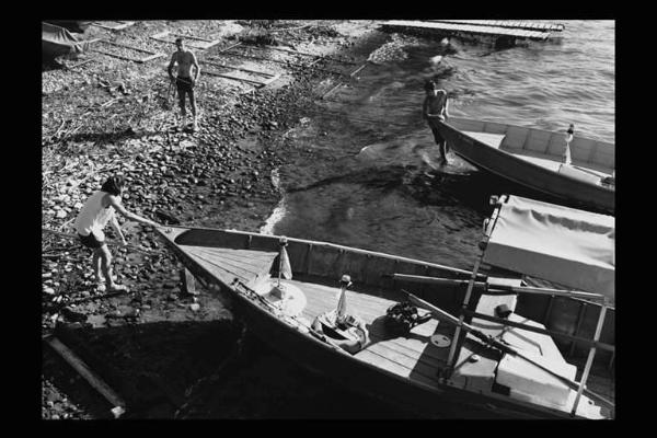 Pescatori spingono in acqua le loro barche.