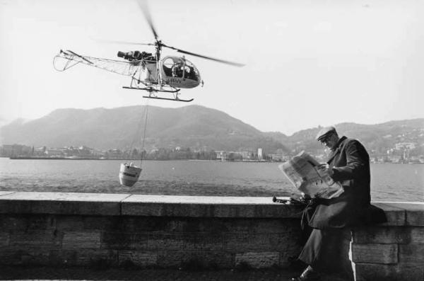 Lettore di un quotidiano in riva al lago.