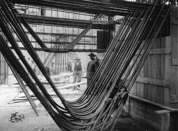 Cantiere del Palazzo dell'INA. Architetto M. Piacentini. Operai al lavoro. Particolare di un'armatura in tondini di ferro.