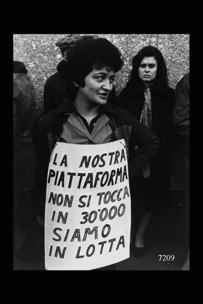 Manifestazione nazionale a Milano. Ritratto di lavoratrice della Siemens che sorregge un cartello recante la scritta:"La nostra piattaforma non si tocca in 30.000 siamo in lotta.