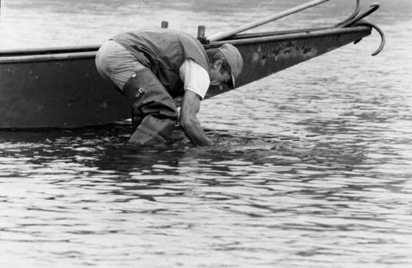 Sergio Cordani. Raccolta di sassi sull'alveo del fiume Ticino.