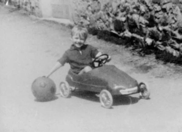 Ritratto infatile - Bambino su un'automobilina a pedali