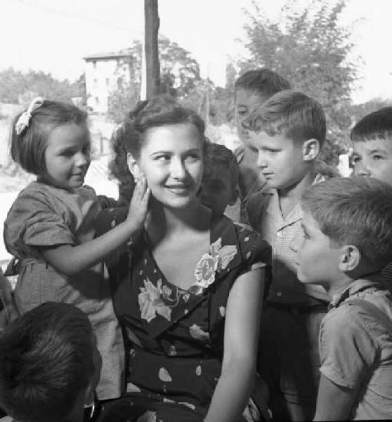 Concorso nazionale per l'elezione di Miss Italia. Salsomaggiore Terme - Ritratto di gruppo: Anna Maria Rossi, Miss Sorriso, in mezzo a dei bambini