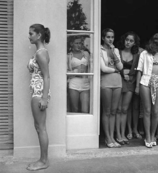 Concorso nazionale per l'elezione di Miss Italia. San Remo - Foto "segnaletica" in costume da bagno - Posa a figura intera di profilo - La concorrente Mariella Giampieri - Le rivali attendono il loro turno