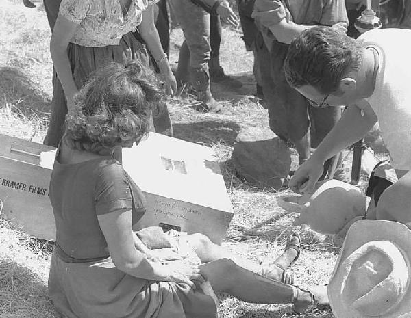 Località non identificata. Sofia Loren sul set del film "Orgoglio e passione" diretto da Stanley Kramer. Un assistente versa acqua sulla gamba dell'attrice