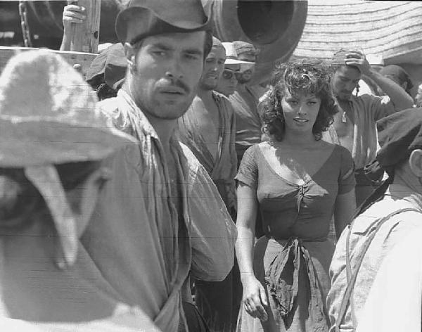 Località non identificata. Sofia Loren sul set del film "Orgoglio e passione" diretto da Stanley Kramer. L'attrice fra un gruppo di comparse