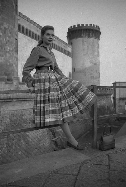 Napoli. Piazza Municipio. Complesso monumentale di Castel Nuovo. L'attrice tedesca Inge Schoner, seduta su una ringhiera, davanti all'entrata del "Maschio Angioino"
