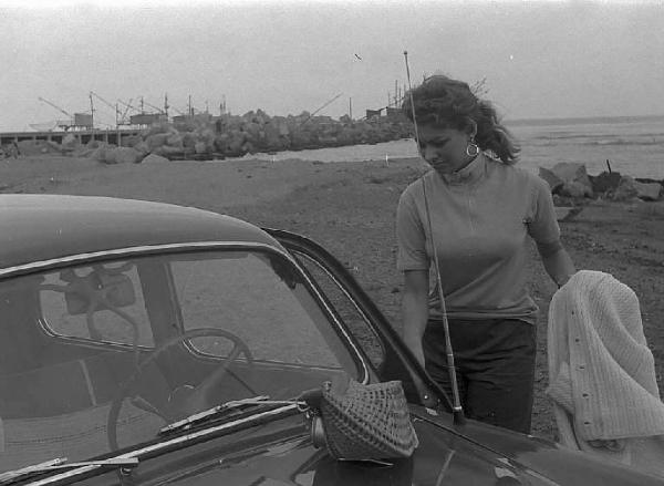 Località non identificata. Sofia Loren, vicino ad un'automobile, sulla spiaggia