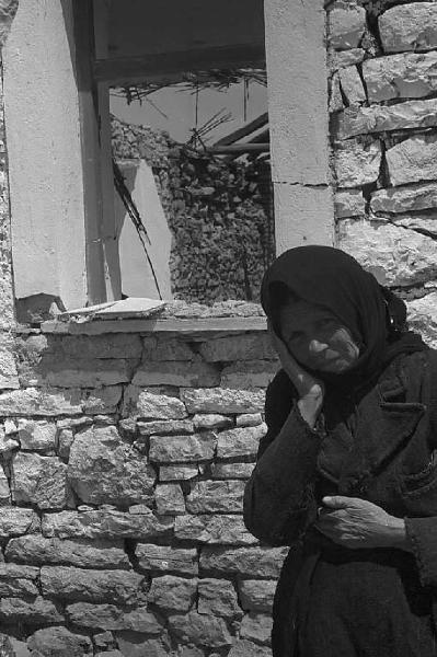 Località non identificata.Terremoto. Donna anziana davanti alle macerie di una casa distrutta dal sisma
