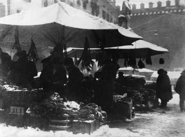 Cremona. Piazza Cavour in un giorno di mercato. Sullo sfondo il monumento di Vittorio Emanuele e le mura del palazzo Comunale.