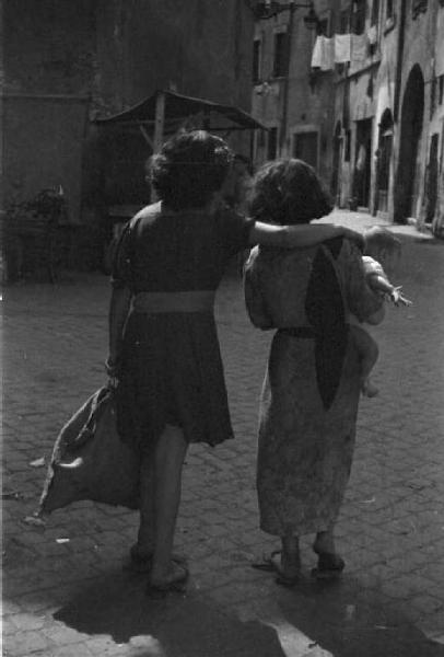 Roma. Quartiere Trastevere. Due donne di spalle con un bambino in braccio
