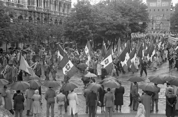 Milano. Piazza Cairoli. Manifestazione monarchica. La folla, con le bandiere, sfila sotto la pioggia