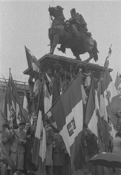 Milano. Piazza del Duomo. Manifestazione monarchica. La folla, con le bandiere, esulta vicino al monumento a Vittorio Emanuele II