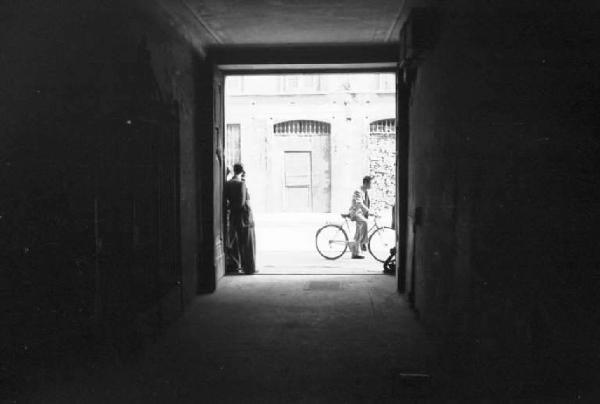 Milano. Quartiere Cinese. Veduta della strada ripresa dall'interno di un portone