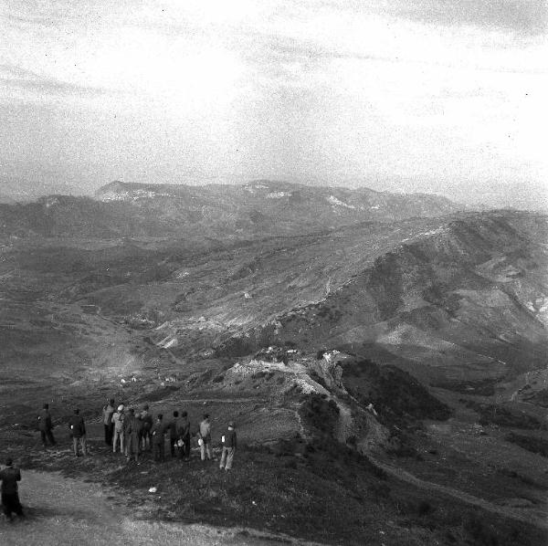 Melissa (Crotone) - Gruppo di uomini ai bordi di una strada che guarda verso la zona delle miniere