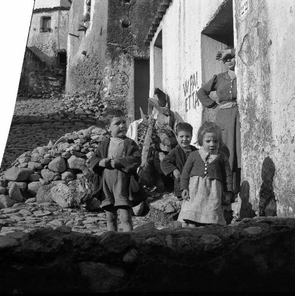 Melissa (Crotone) - Donna e bambini sull'uscio di una casa