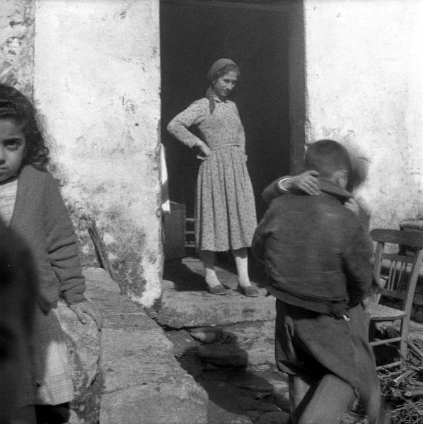 Melissa (Crotone) - Donna e bambini all'esterno di una casa