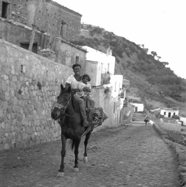 Melissa (Crotone) - Contadino con bambina su cavallo in una strada