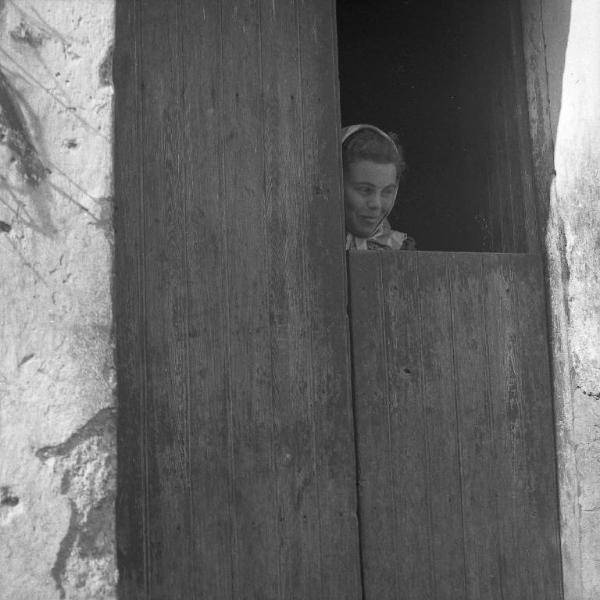 Melissa (Crotone) - Donna dietro una porta di casa semichiusa