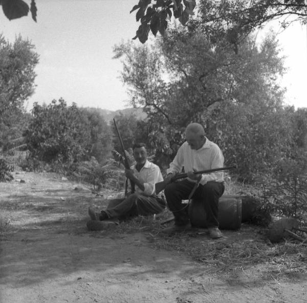 Melissa (Crotone) - Due contadini con fucili da caccia in un viottolo di campagna