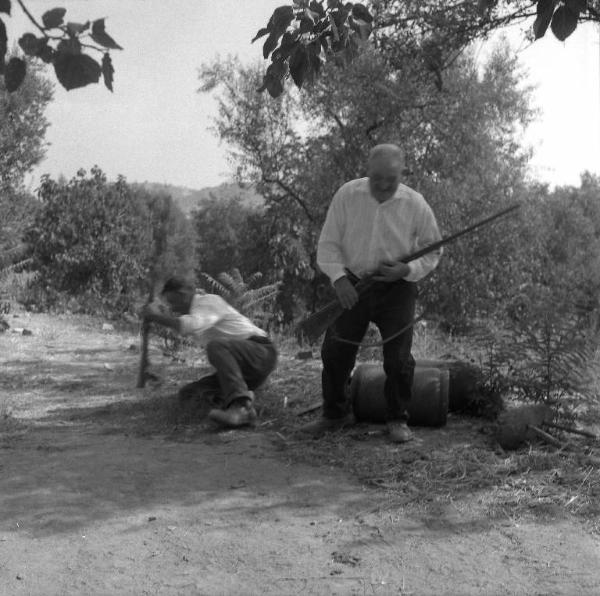 Melissa (Crotone) - Due contadini con fucili da caccia in un viottolo di campagna