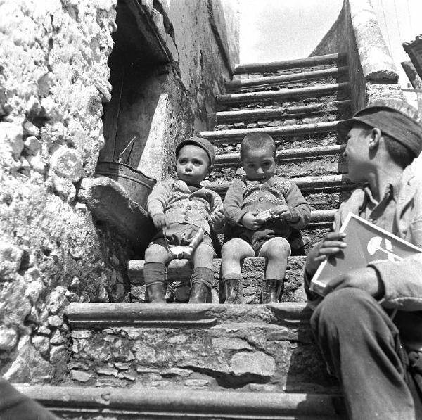 Melissa (Crotone) - Due bambini e un ragazzo sulla scala esterna di una casa