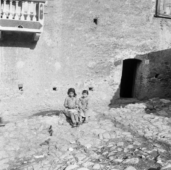 Melissa (Crotone) - Due bambine sedute in una strada