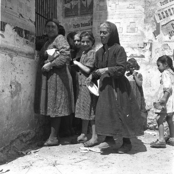 Melissa (Crotone) - Donne e bambine in attesa della distribuzione di cibo presso un edificio