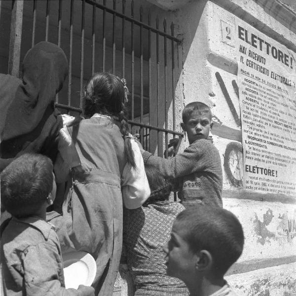 Melissa (Crotone) - Donne e bambini in attesa della distribuzione di cibo presso un edificio