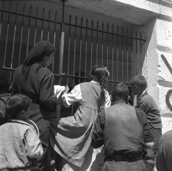 Melissa (Crotone) - Persone e bambini in attesa della distribuzione di cibo presso un edificio