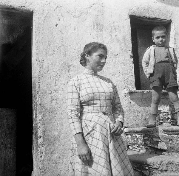 Melissa (Crotone) - Giovane donna e bambino all'esterno di una casa