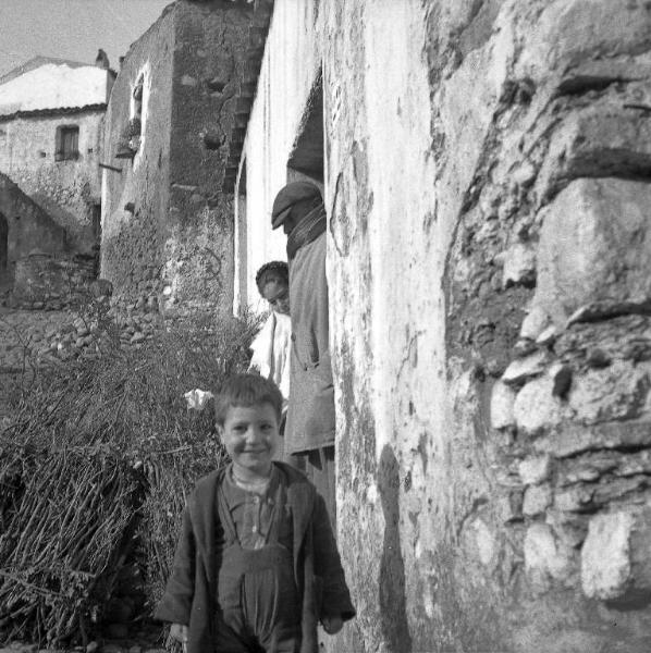 Melissa (Crotone) - Uomo e bambini sull'uscio di una casa