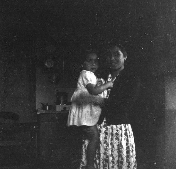 Melissa (Crotone) - Donna con bambina in braccio nella cucina di una casa - Ritratto