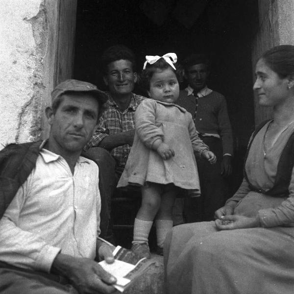 Melissa (Crotone) - Famiglia di contadini con bambina al centro sull'uscio di una casa