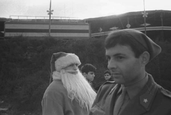 Piero d'Alfonso vestito da Babbo Natale e un militare al Luna Park delle Varesine