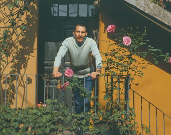 Milano, Via Fiori Chiari - Ritratto maschile - Tomshinsky Stanley affacciato a un balcone con rose rampicanti