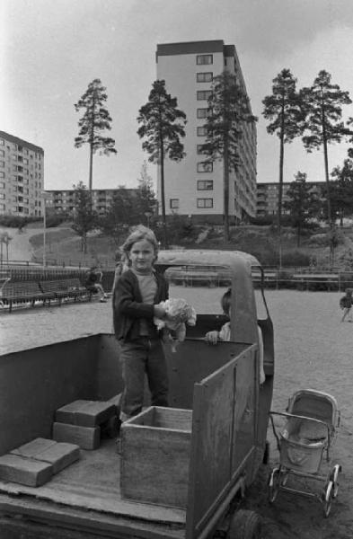Svezia - Bambina che gioca su di un furgoncino - Sullo sfondo palazzi cittadini