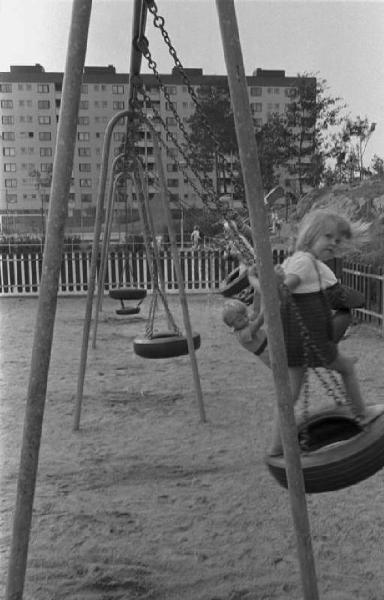 Svezia - Bambini che giocano in un parco giochi cittadino - Sullo sfondo palazzi di periferia