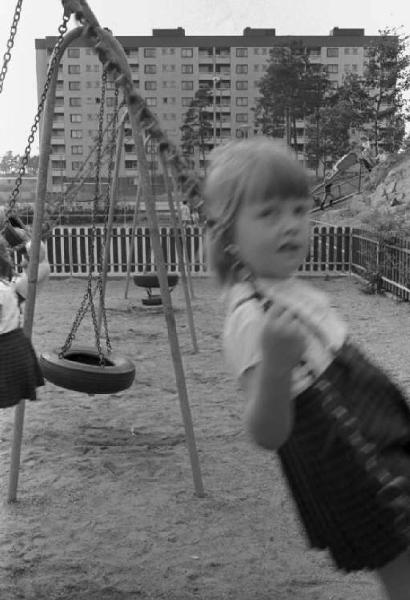 Svezia - Bambina che gioca in un parco giochi cittadino - Sullo sfondo palazzi di periferia